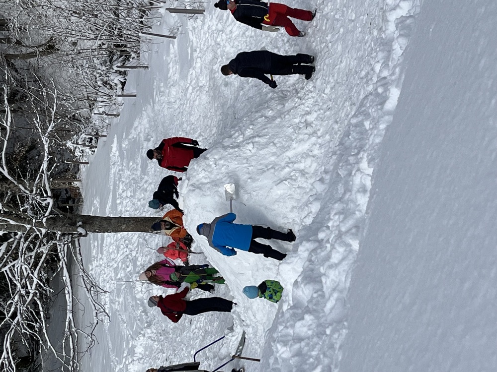 Väter und Kinder bauen ein Iglu